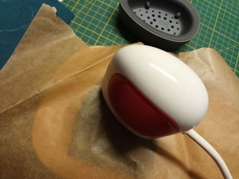Cricut Mini-Presse presst das Gesicht durch Backpapier auf den Stoff.