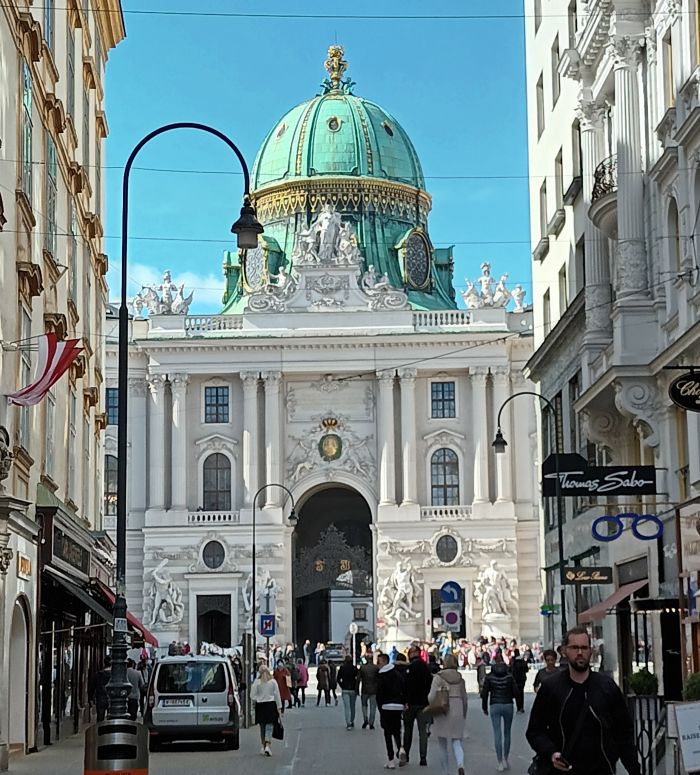 Anblick der Hofreitschule in Wien -zwischen den Häusern .schaut man auf ein imposantes Gebäude mit kupferner Kuppel.