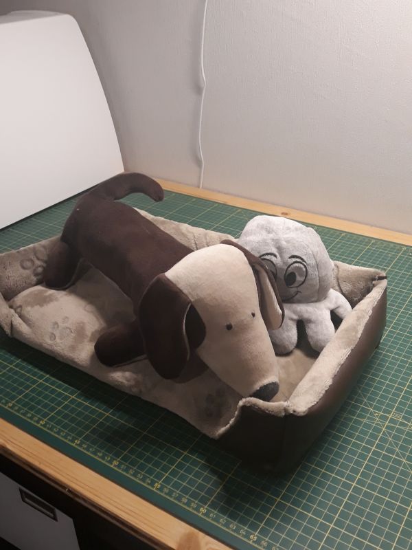 Stoffhund und weitere Kraken in einem selbstgenähten Minihundebett.