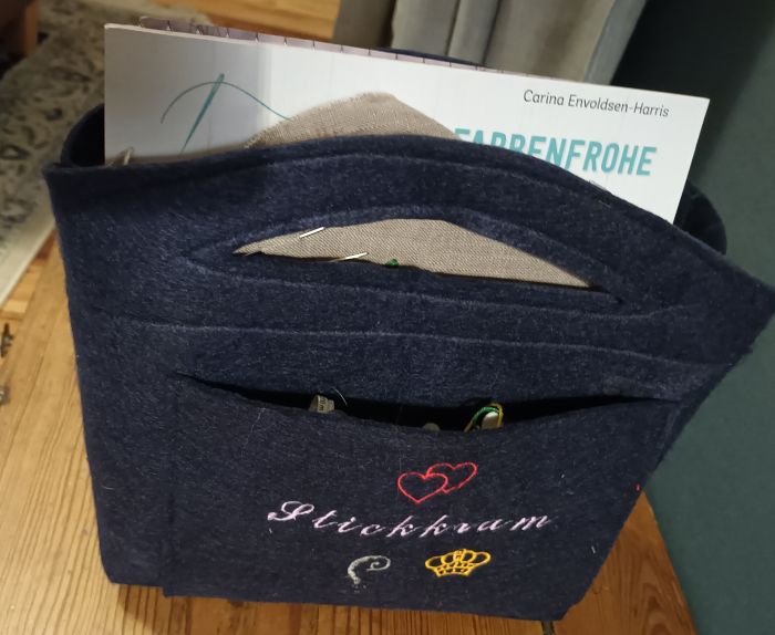 Befüllter Filz-Organizer mit Stickmaterial, bereit zur Nutzung im Wohnzimmer.