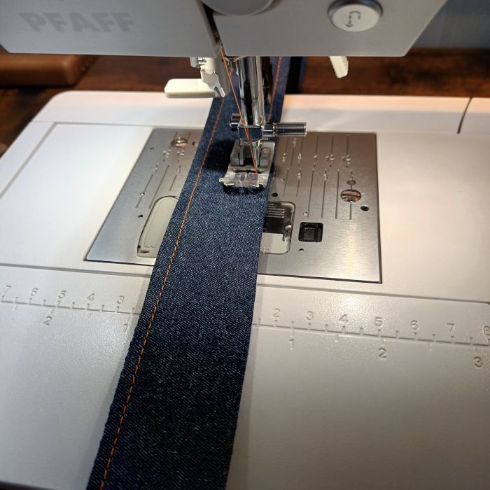 Ein Jeanshalsband wird mit der Nähmaschine genäht